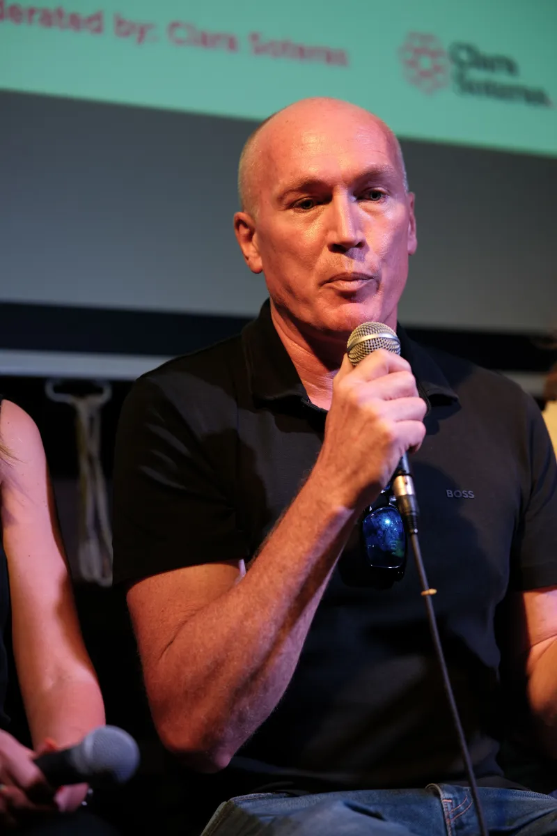 Steven Wilson-Beales speaking into a microphone on a panel at The Audience Club, London.